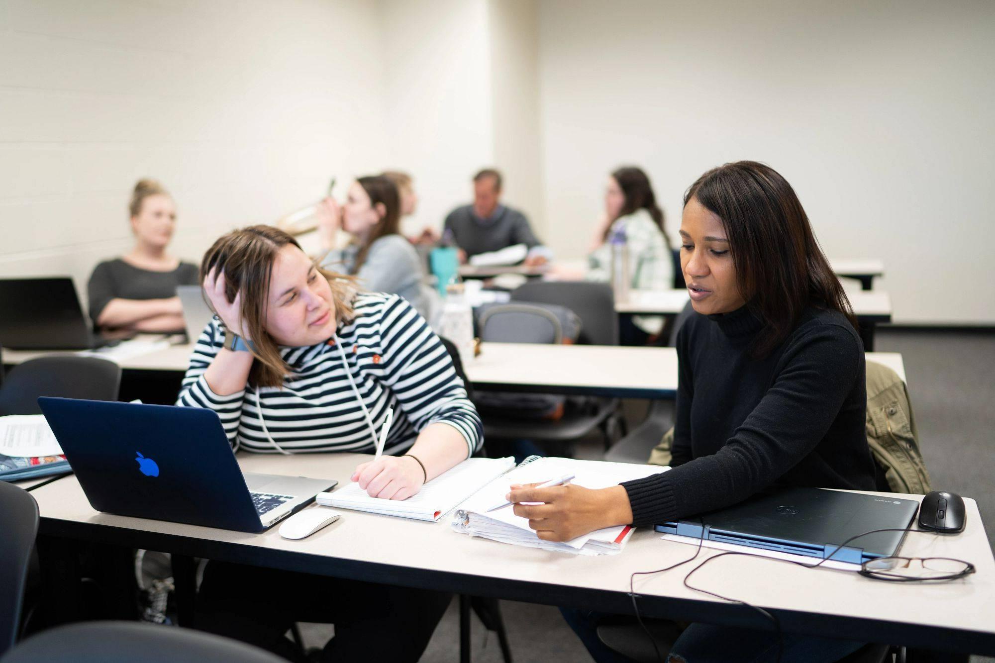 Two adult learners collaborate on an assignment